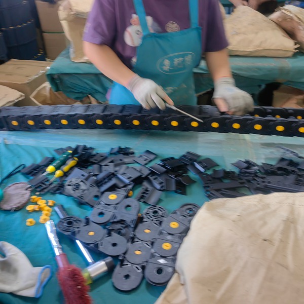 Workers inspecting and manually connecting modular plastic cable track sections